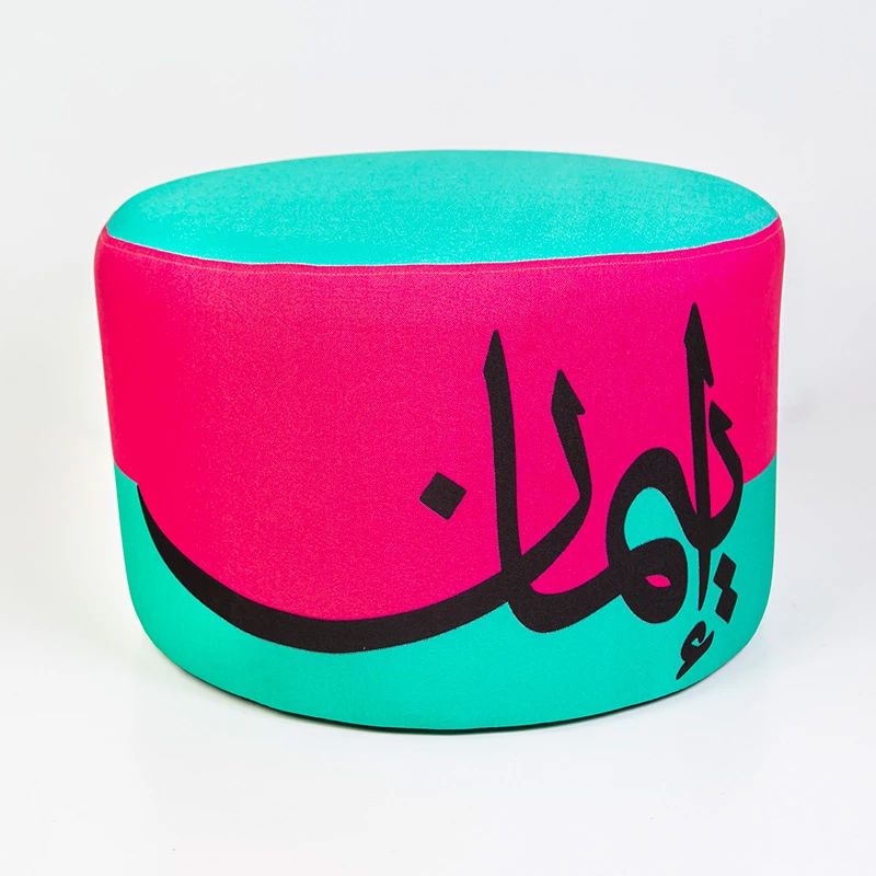مقعد عثماني مودرن مبطن – تصميم فني بكلمة "إيمان" بالخط العربي وألوان زاهية (وردي وفيروزي) - مؤسسة الحسين للسرطان