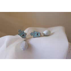 Unique drop earrings combining the Hamsa hand charm, embellished with turquoise zircon, with a marbled oval bead handcrafted from polymer clay. A stylish piece that reflects cultural beauty and symbolic protection